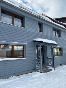 a gray building with a door in the snow at Ferienwohnung Am Graben in Hasselfelde