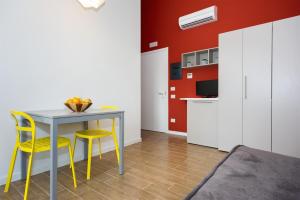 a kitchen with a table and two yellow chairs at Vele Storiche Pisane - free private parking in Pisa