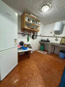 a kitchen with a white refrigerator and a wooden floor at CHY dreams in Cabo Negro