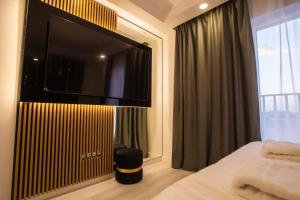 a bedroom with a flat screen tv on a wall at Klaus Luxury Apartment #Bucharest in Ştefăneştii de Sus