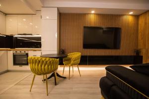 a living room with a table and chairs and a tv at Klaus Luxury Apartment #Bucharest in Ştefăneştii de Sus