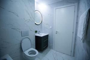 a bathroom with a toilet and a sink and a mirror at Klaus Luxury Apartment #Bucharest in Ştefăneştii de Sus