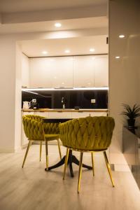 a kitchen with two green chairs and a counter at Klaus Luxury Apartment #Bucharest in Ştefăneştii de Sus