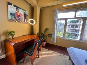 a room with a desk and a chair and a window at Sunny Side Up top-floor apartment in Kathmandu