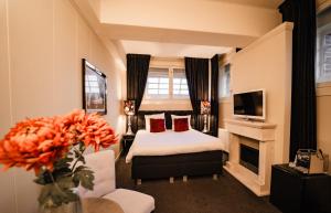 a hotel room with a bed and a tv at Hotel Huis van Bewaring - Bijzonder boutique hotel in historisch pand in Almelo