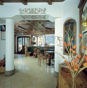 een lobby met een tafel en stoelen in een gebouw bij Hotel Ai Pini in Vigo di Fassa