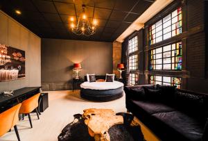 a living room with a couch and a table at Hotel Huis van Bewaring - Bijzonder boutique hotel in historisch pand in Almelo