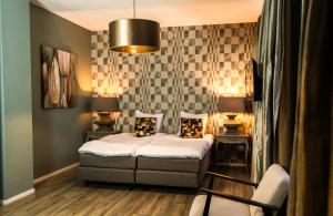 a bedroom with a bed and a pendant light at Hotel Huis van Bewaring - Bijzonder boutique hotel in historisch pand in Almelo