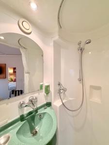a bathroom with a green sink and a shower at Fasthotel Orleans Zénith in Orléans