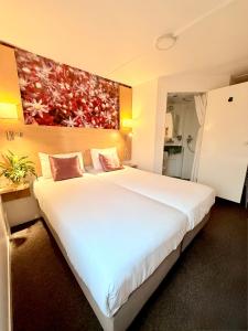 a large white bed in a hotel room at Fasthotel Orleans Zénith in Orléans