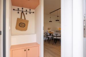 a kitchen and dining room with a pink cabinet at Hello Zeeland - De Brabander Wijk 111 in Cadzand
