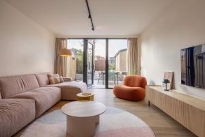 a living room with a couch and a table at Hello Zeeland - De Brabander Wijk 111 in Cadzand +17 photos