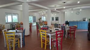 ein Esszimmer mit Tischen und bunten Stühlen in der Unterkunft Agriturismo Fattoria delle Milizie in Scicli
