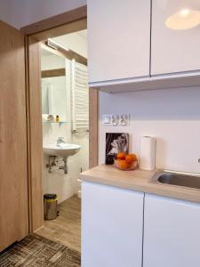 een keuken met een wastafel en een fruitschaal op een aanrecht bij Al-Dom Apartamenty, Apartament SUN w Welle z dostępem do sauny i jacuzzi in Grzybowo