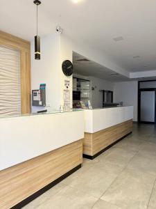 a restaurant counter with a clock on the wall at Al-Dom Apartamenty, SUN w Welle z dostępem do sauny i jacuzzi in Grzybowo