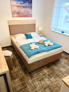 een slaapkamer met een bed met handdoeken erop bij Al-Dom Apartamenty, Apartament SUN w Welle z dostępem do sauny i jacuzzi in Grzybowo