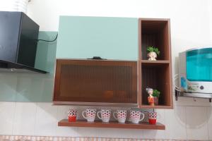 a kitchen with a row of white vases on shelves at Thiruveesar Family Retreat near Airport in Tiruchirappalli +10 photos