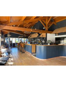 a restaurant with a bar and tables and chairs at Chalet KABANA in Saint-Hilaire-de-Riez