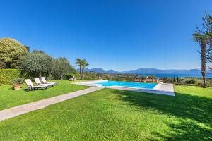 a backyard with a swimming pool and a grass yard at Villa Perla by Whale Homes in Lonato