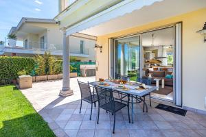 a table and chairs on a patio with a house at Villa Perla by Whale Homes in Lonato