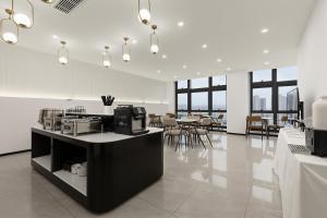 una stanza con bancone e tavoli e sedie di chongqing Qinin Hotel a Chongqing