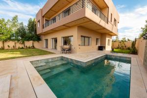 a house with a swimming pool in front of a house at Villa Soliya 4 Rooms with private pool in Marrakesh