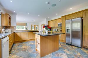 a kitchen with wooden cabinets and a stainless steel refrigerator at 7 Bed in Ashton oc-p00891 in Germoe
