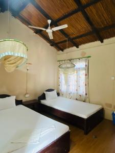 een slaapkamer met twee bedden en een plafondventilator bij Annapurna View Lodge in Chitwan