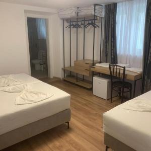 a room with two beds and a table and a desk at Vintage Villa in Shkodër