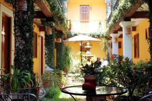 cortile con tavolo, sedie e piante di Hotel Dainzu a Città di Oaxaca