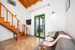 a living room with a couch and a staircase at Villa Martha in Ieromónachos