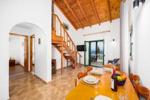 a dining room with a table and a staircase at Villa Martha in Ieromónachos