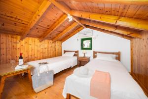 two beds in a room with wooden ceilings at Villa Martha in Ieromónachos +15 photos