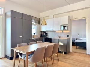 a kitchen and dining room with a wooden table and chairs at Ski-Inn Huoneisto in Vuokatti