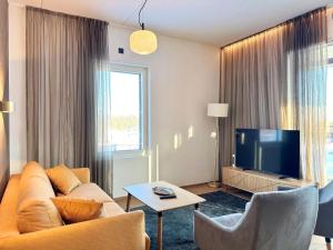 a living room with a couch and a tv at Ski-Inn Huoneisto in Vuokatti