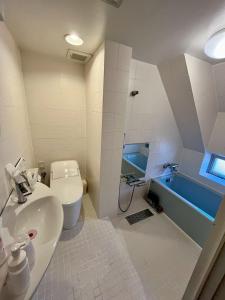 een badkamer met een wastafel, een toilet en een bad bij Hotel RIO新宿 in Tokyo