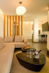 a living room with a couch and a table with wine glasses at Secret Path Luxury Villas in Imerovigli