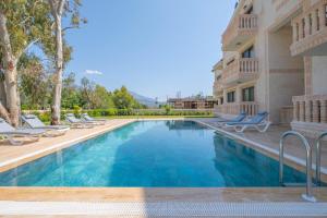 a swimming pool with lounge chairs next to a building at Kalender Pansiyon Fethiye in Fethiye