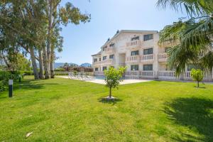a building with a grassy yard in front of it at Kalender Pansiyon Fethiye in Fethiye