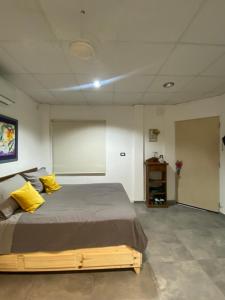 a bedroom with a large bed with yellow pillows at Monoambiente Smart en Corrientes in Corrientes