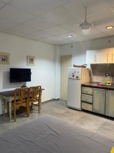 a kitchen with a table and a white refrigerator at Monoambiente Smart en Corrientes in Corrientes