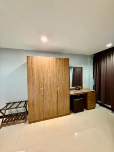 a room with a large wooden cabinet and a desk at Sampheng Apartment in Bangkok