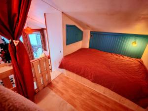 a bedroom with a red bed in a room at Le Cozy in Aragnouet +4 photos