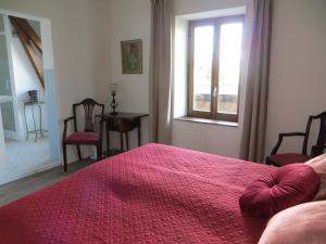 a bedroom with a red bed and a window at Les Meules in Saint-Basile