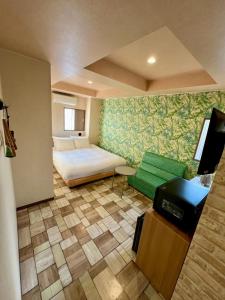 een slaapkamer met een bed, een bank en een tafel bij Hotel RIO新宿 in Tokyo