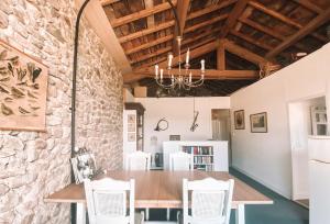 a dining room with a wooden table and white chairs at Les Meules in Saint-Basile