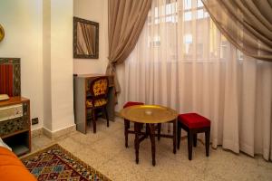a living room with a table and chairs and a window at Hotel Chellah in Tangier