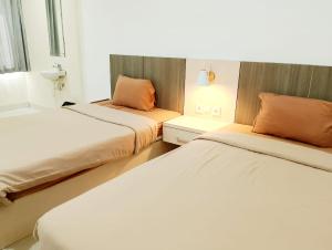 2 letti in una piccola camera con 2 letti di Tembok Batu Residence a Jetis Altre 50 foto