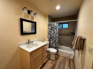 a bathroom with a sink and a toilet and a shower at Waterfront Log Cabin - Sunriver in Bend +73 photos