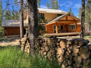 a log cabin with a wall of logs in front of it at Waterfront Log Cabin - Sunriver in Bend